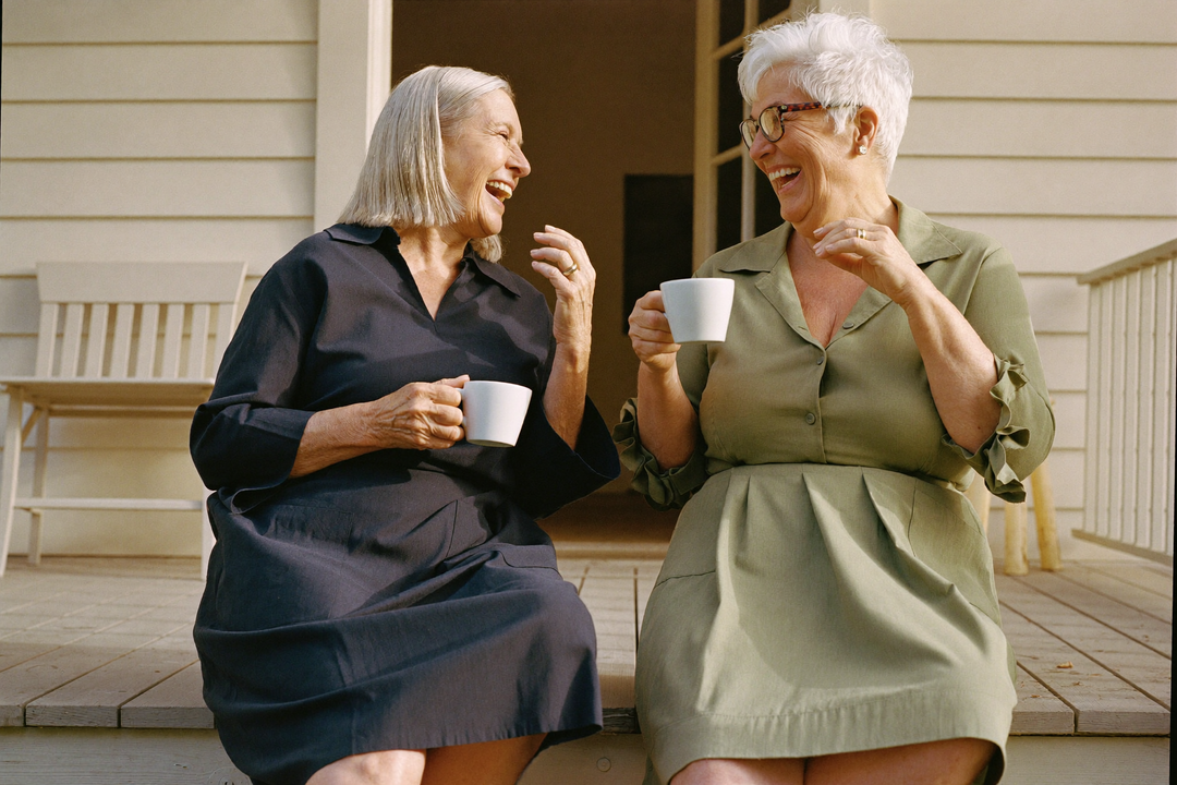 Bonny and Rose laughing on the porch steps with coffee