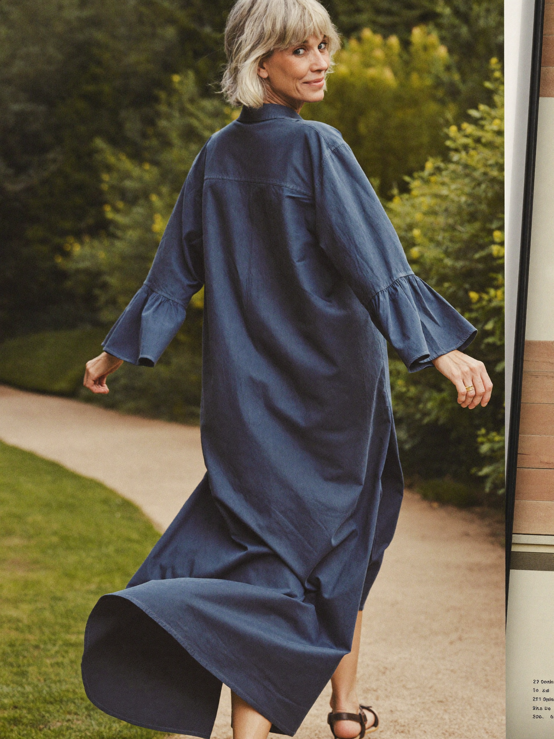 Back view of the navy dress, loose through the back, hem at the knee